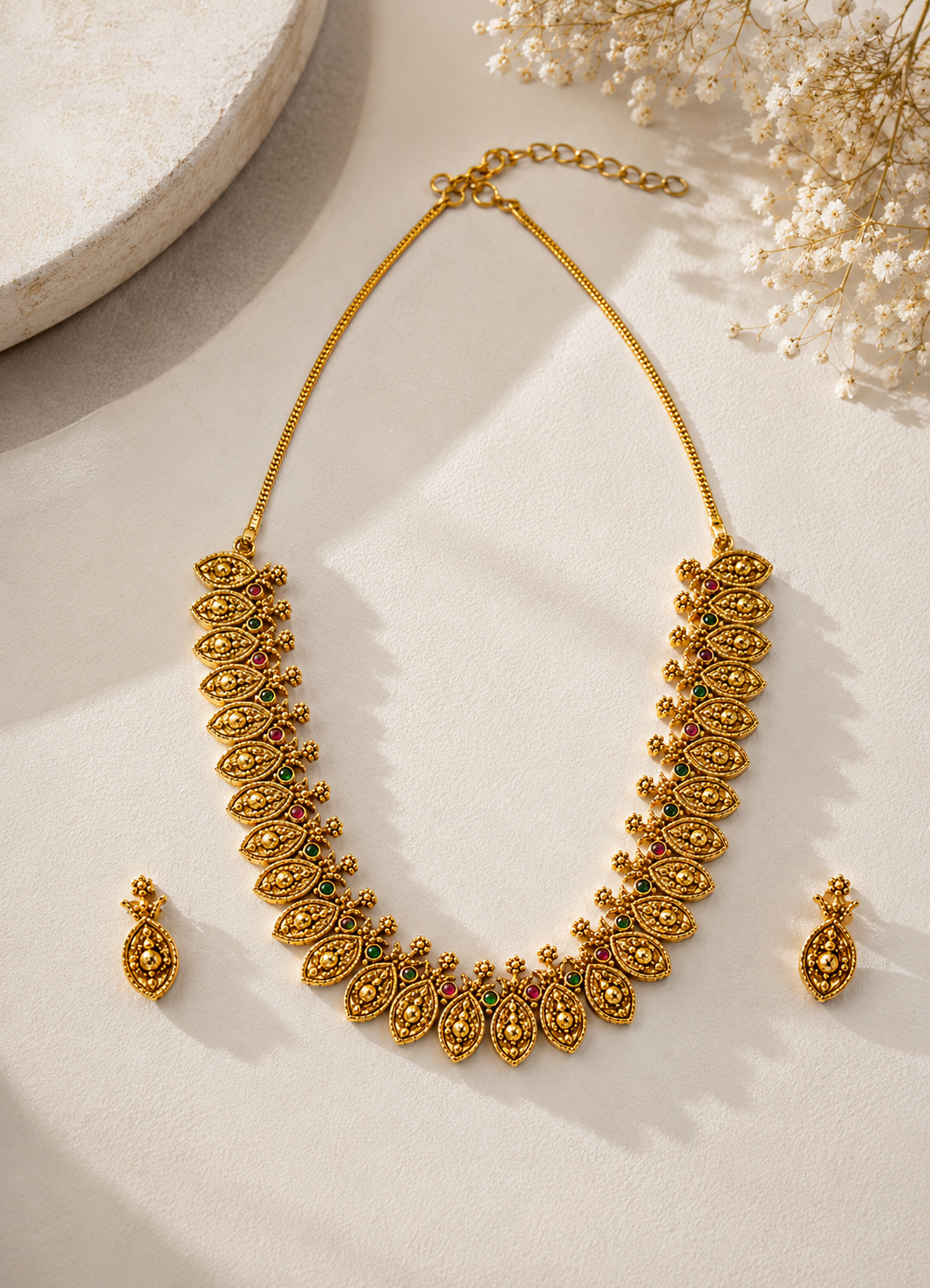 Elegant antique gold leaf necklace set featuring red and green stone detailing.