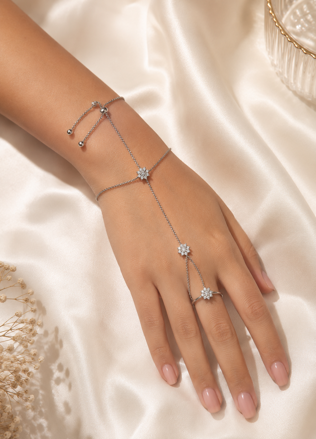 Woman wearing Celestia silver floral crystal hand harness bracelet ring with adjustable chain.