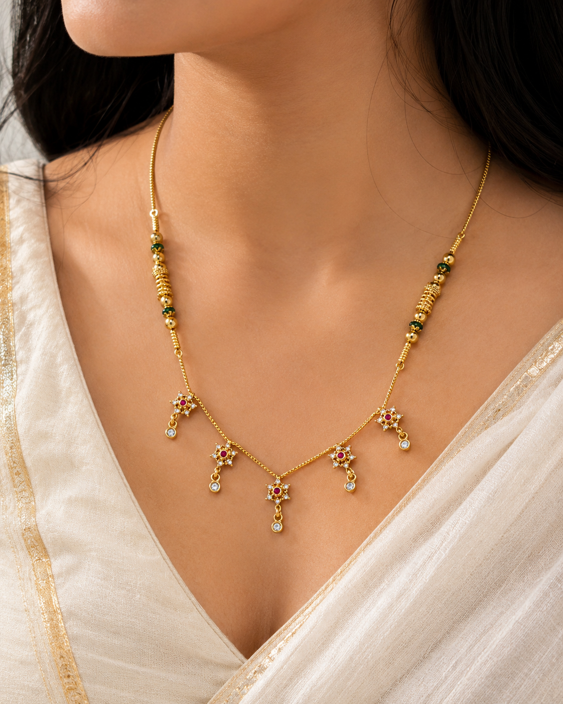 ORELVA Aarohi floral gold-plated mangalsutra necklace worn by a woman with sparkling floral crystal charms.