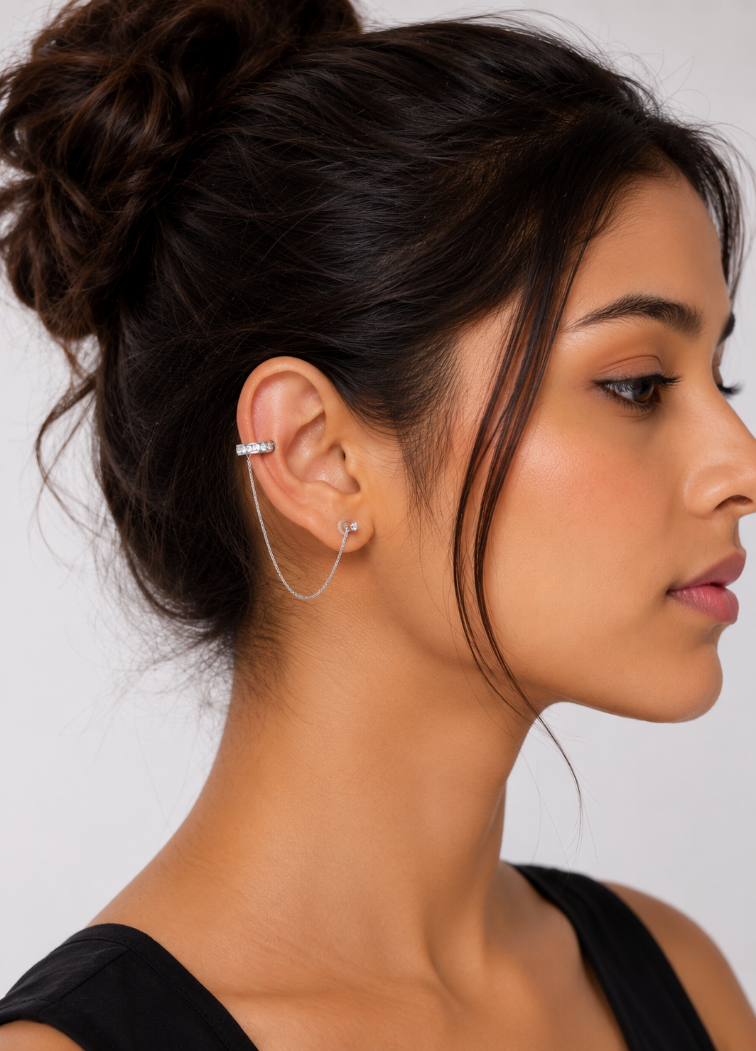 Woman wearing Orelva silver chain ear cuff stud earrings with sparkling cubic zirconia stones.