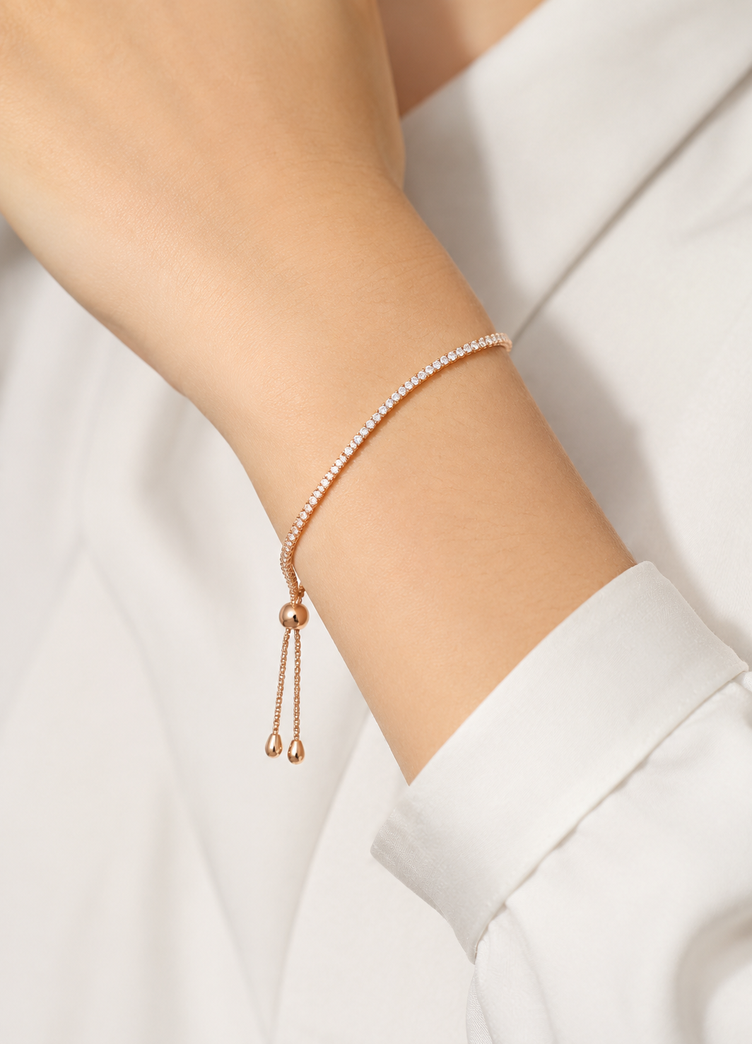 Orelva rose gold crystal tennis bracelet worn on a woman's wrist
