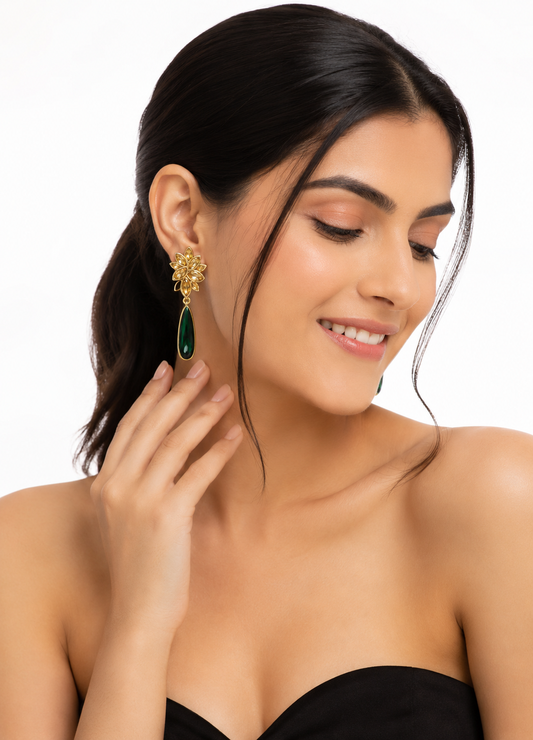 ORELVA Emerald Muse green crystal gold-plated drop earrings worn by a woman.