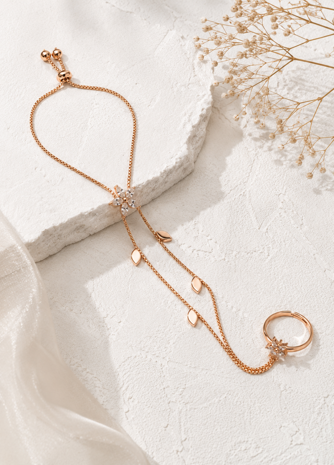 Orelva rose gold floral hand harness bracelet with crystal flower centerpiece displayed on a premium flat lay.
