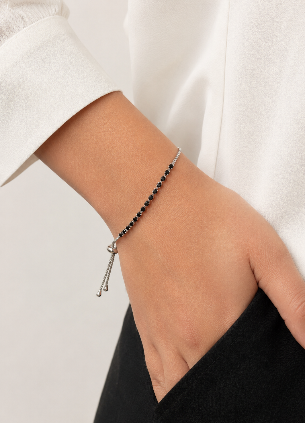 Woman wearing ORELVA Noir black crystal adjustable silver slider bracelet.