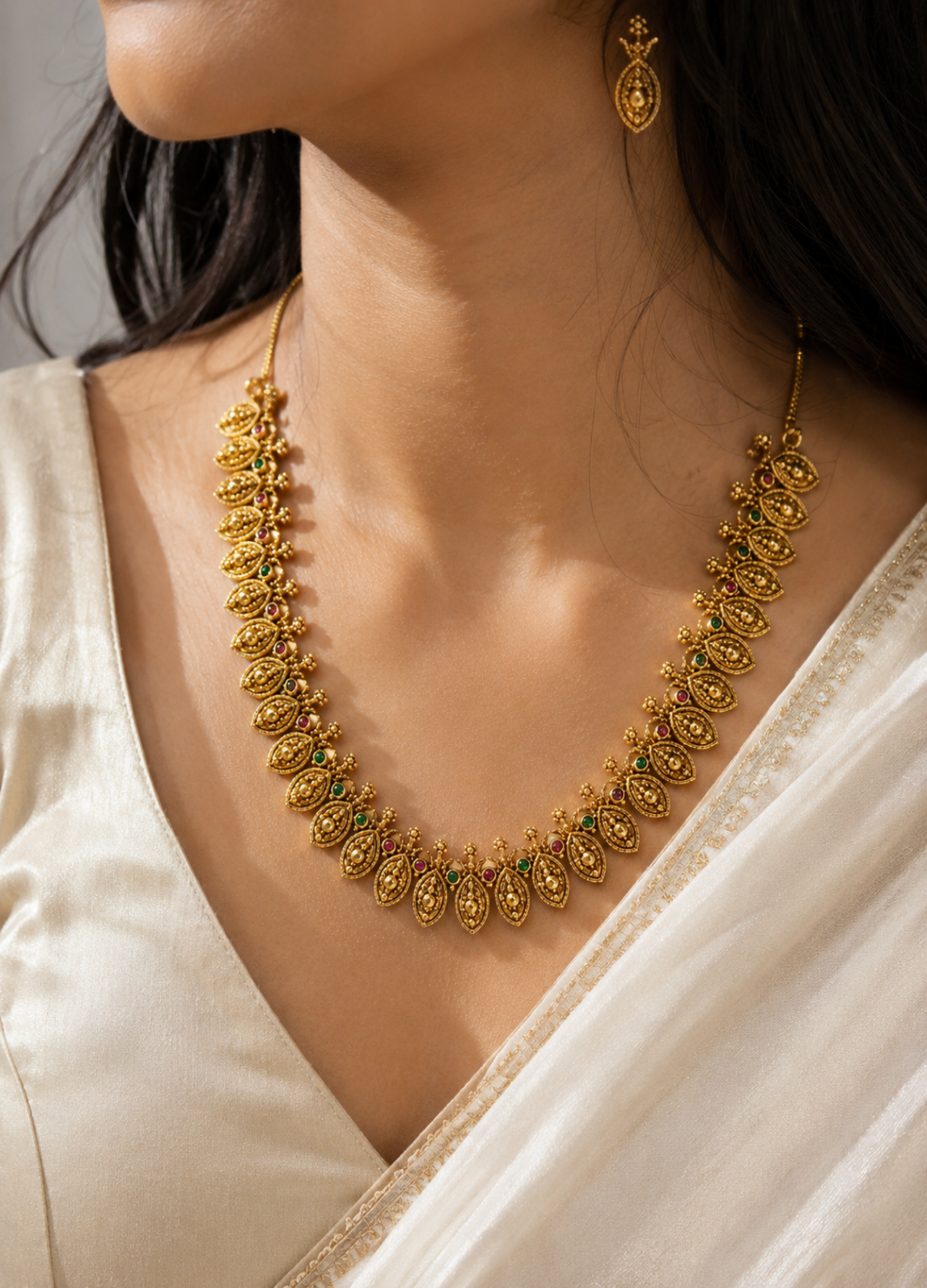 Traditional gold-tone leaf necklace set with matching earrings for women.