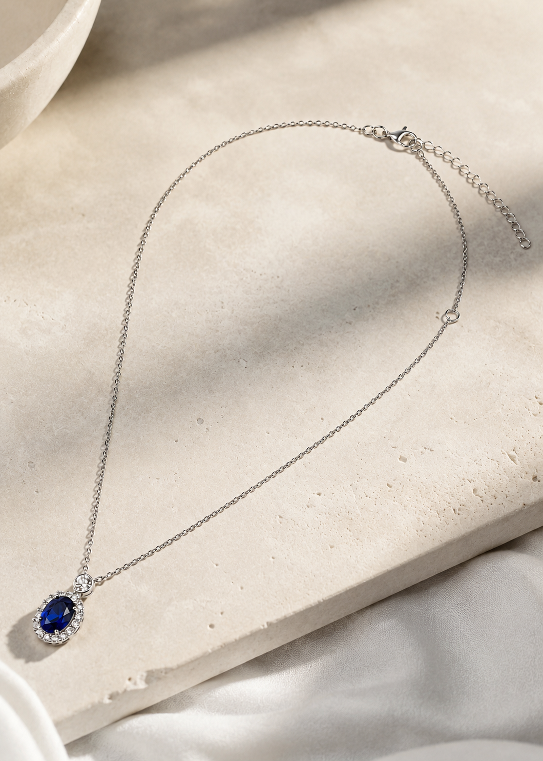 Luxury sterling silver halo necklace featuring a royal blue cubic zirconia pendant