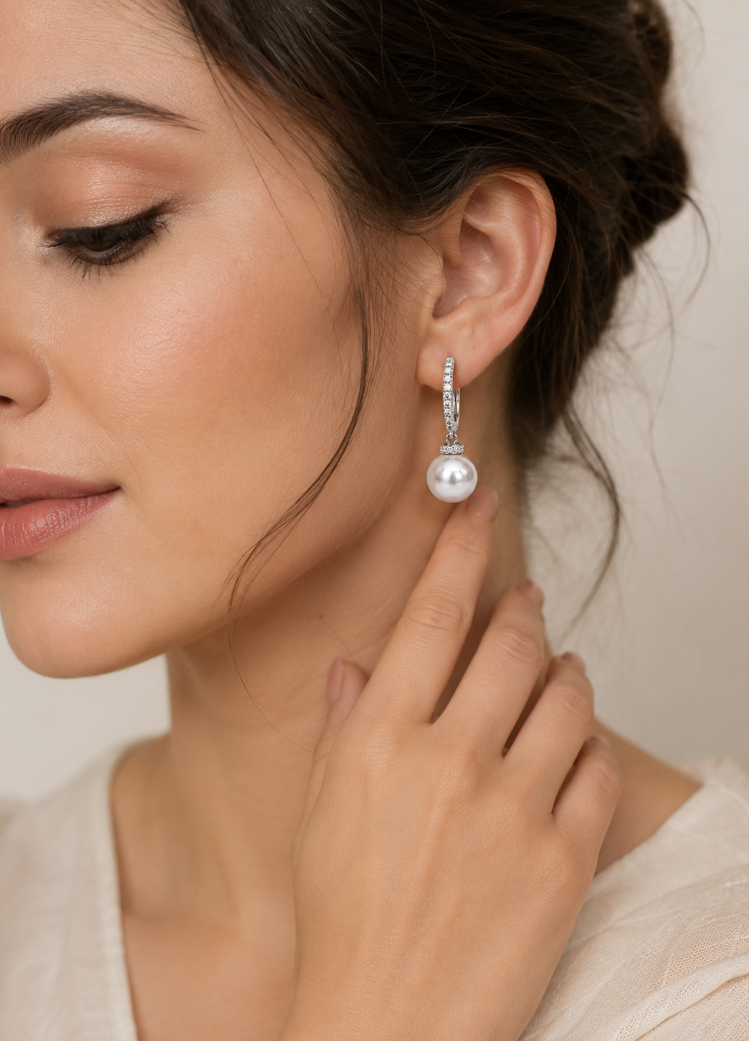 Model wearing Luna Pearl silver CZ hoop earrings with elegant white pearl drop.