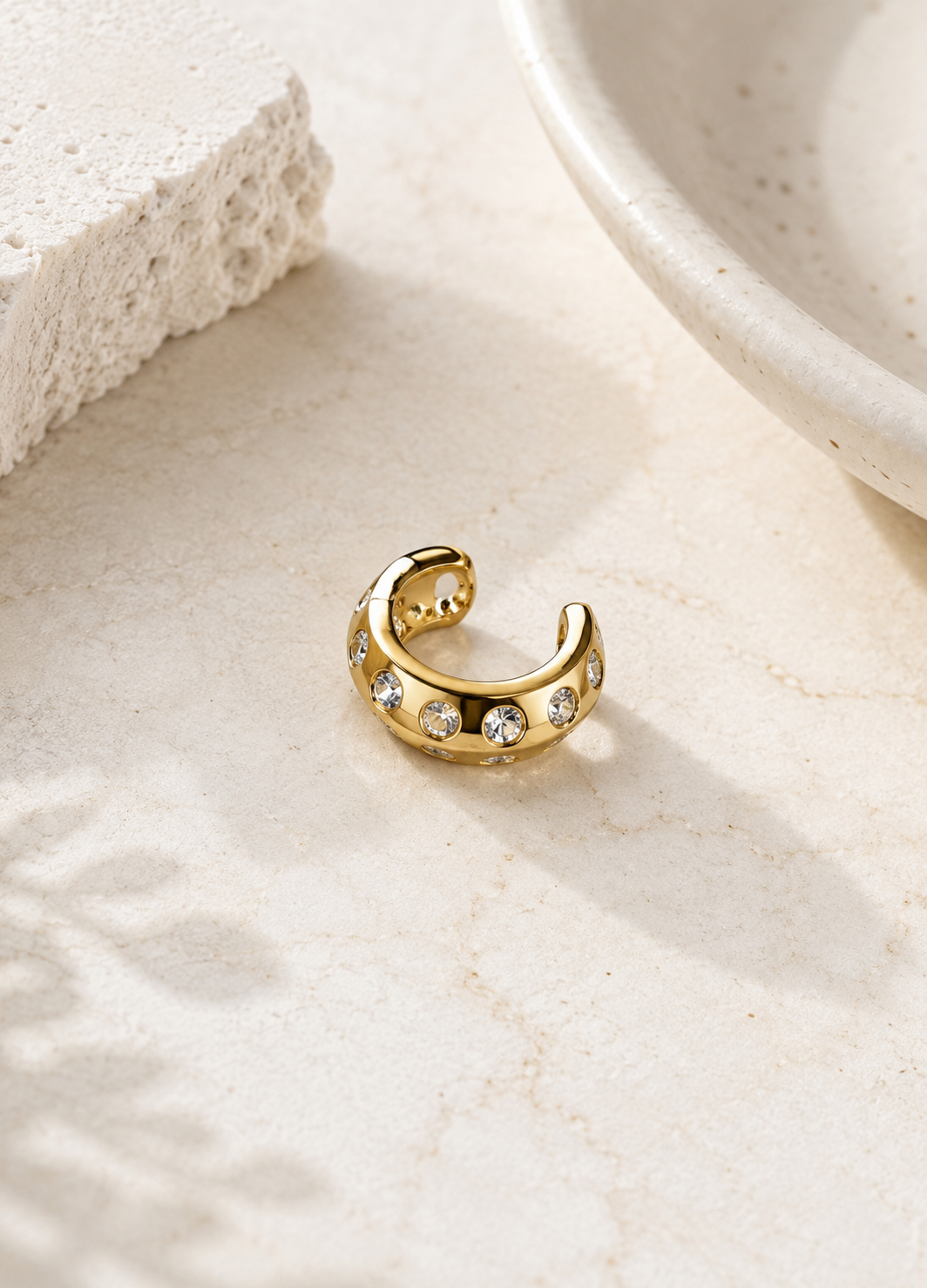 Close-up of Orelva gold ear cuff featuring sparkling crystal accents and an open adjustable fit