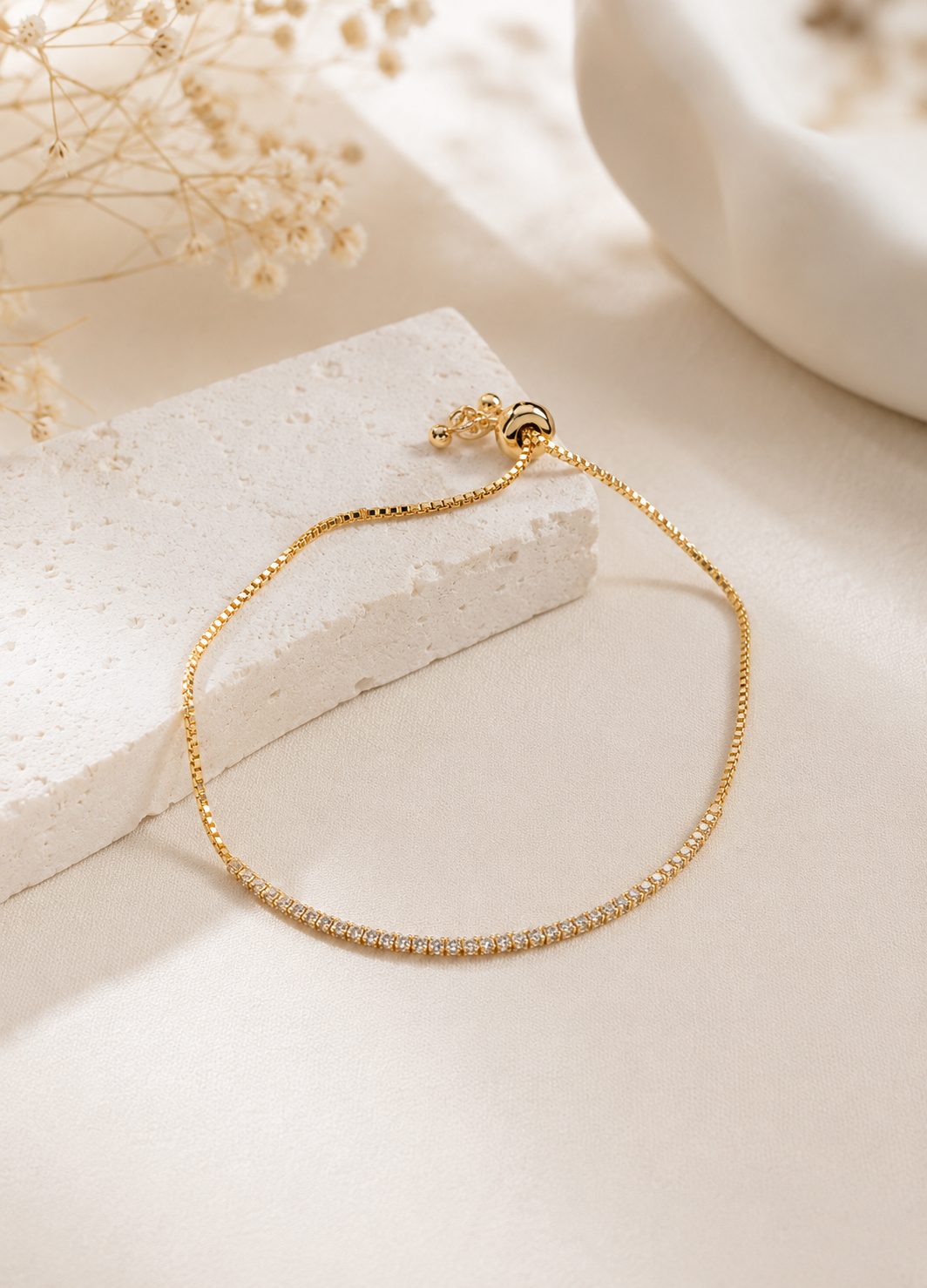 Gold adjustable tennis bracelet with sparkling crystal stones by Orelva
