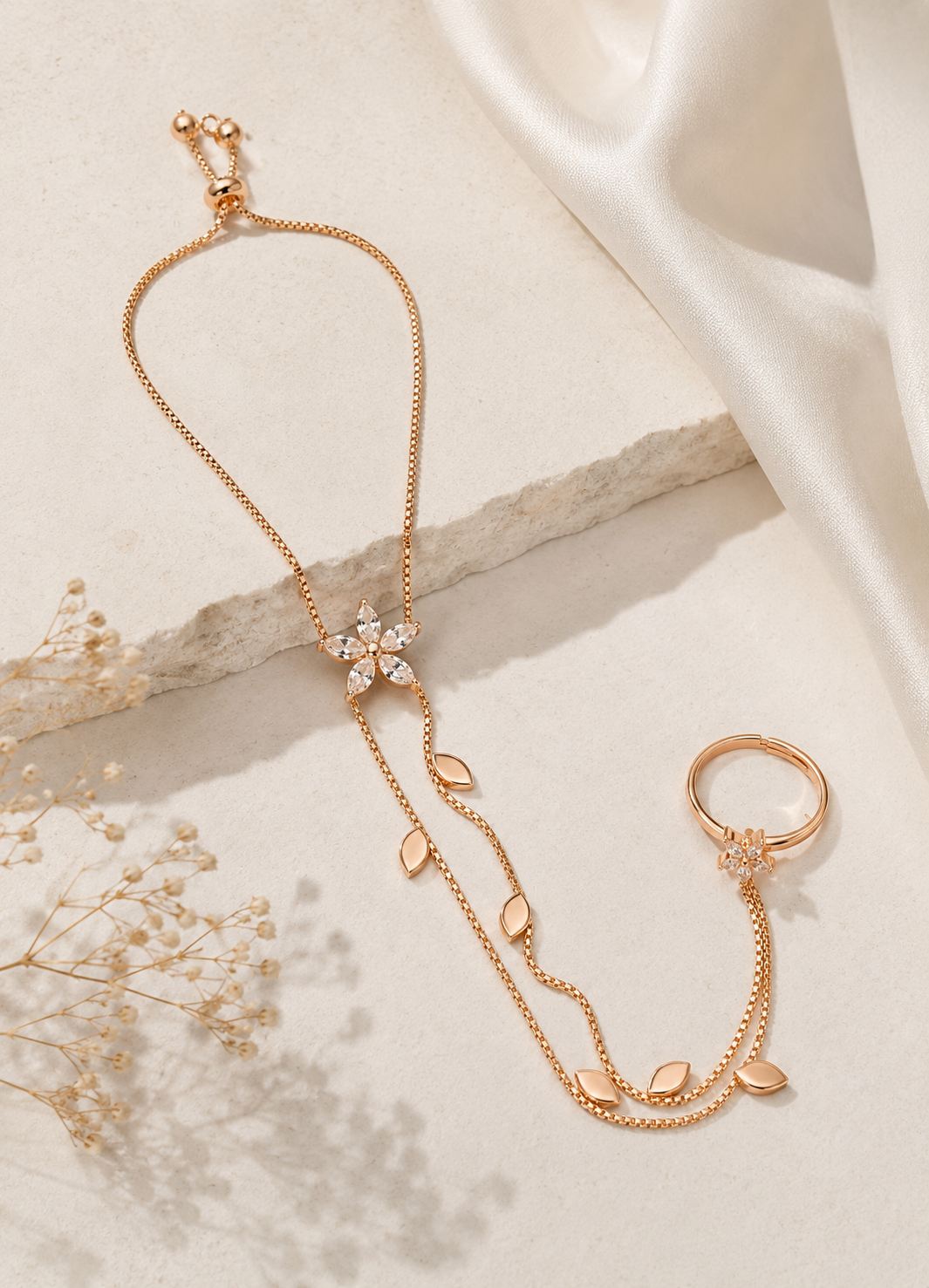Orelva adjustable rose gold hand harness bracelet with floral crystal design, decorative leaf accents, and matching finger ring.