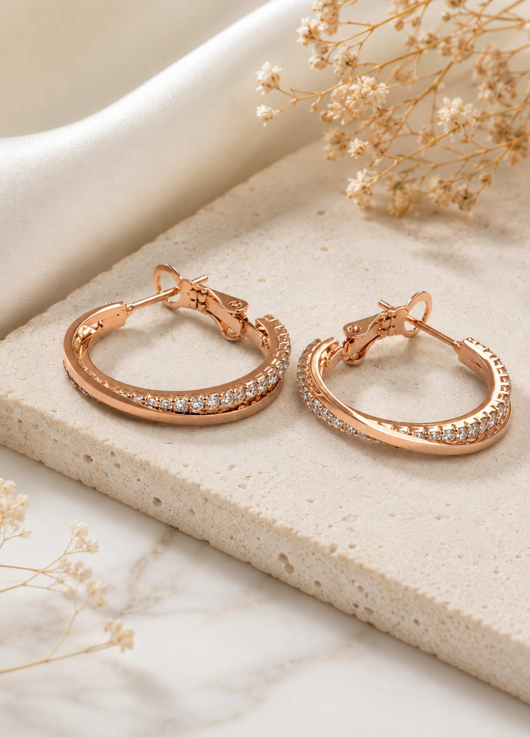Front view of ORELVA Celeste rose gold crystal hoop earrings with secure hinged snap closure.
