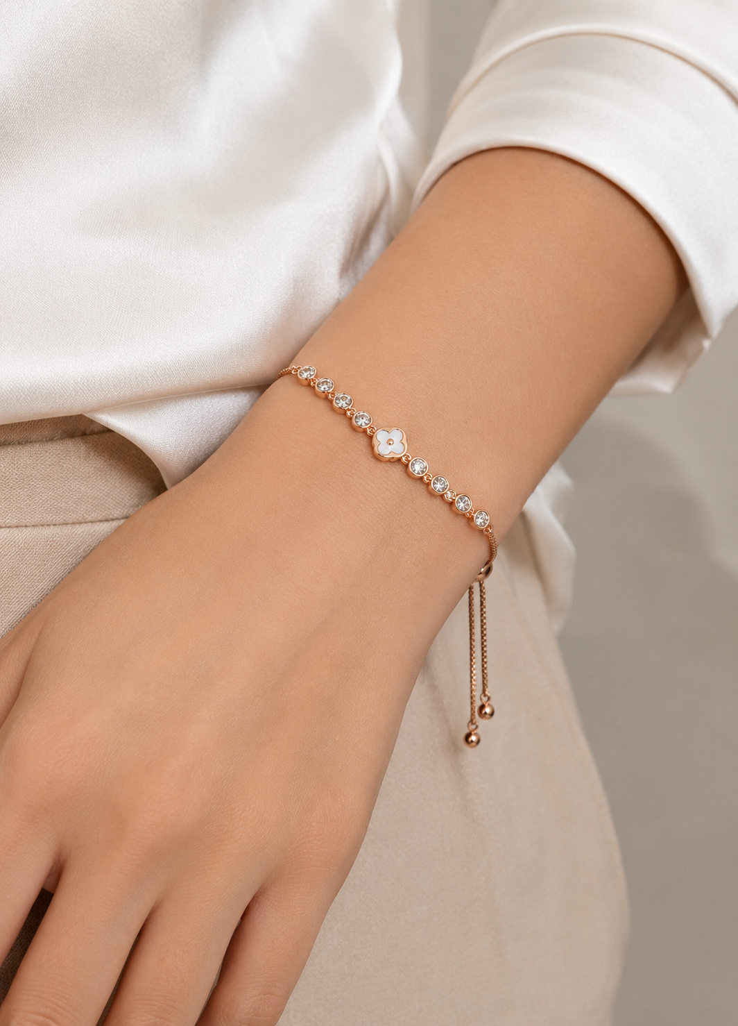 Orelva crystal clover rose gold bracelet worn on a woman's wrist