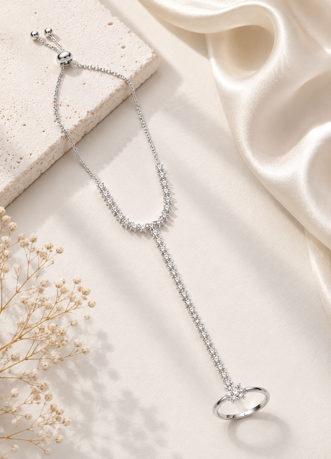 Flat lay of Orelva adjustable silver crystal hand chain bracelet ring on a premium neutral background.