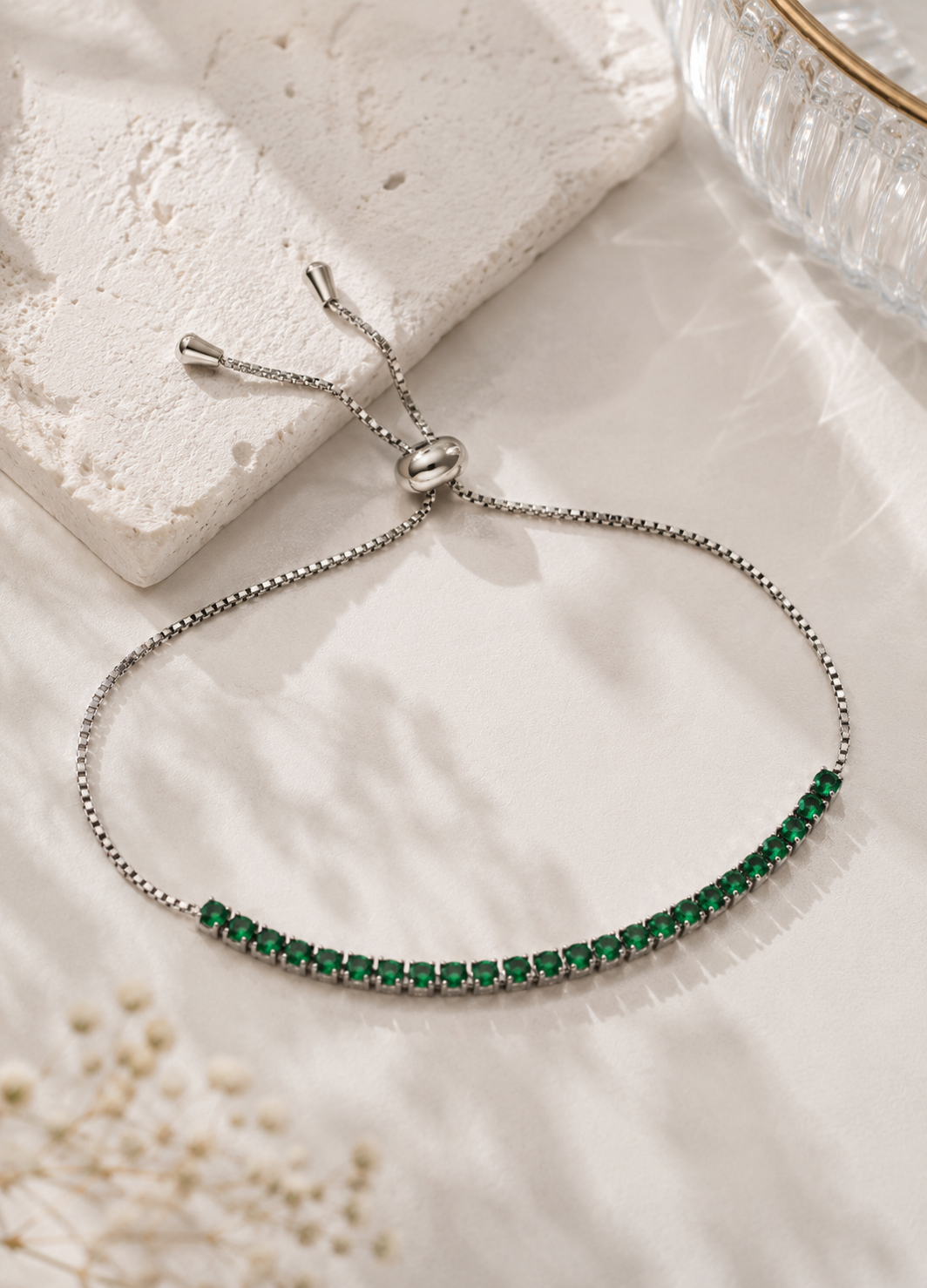 ORELVA Emerald Glow silver-plated adjustable bracelet featuring emerald green crystal stones.