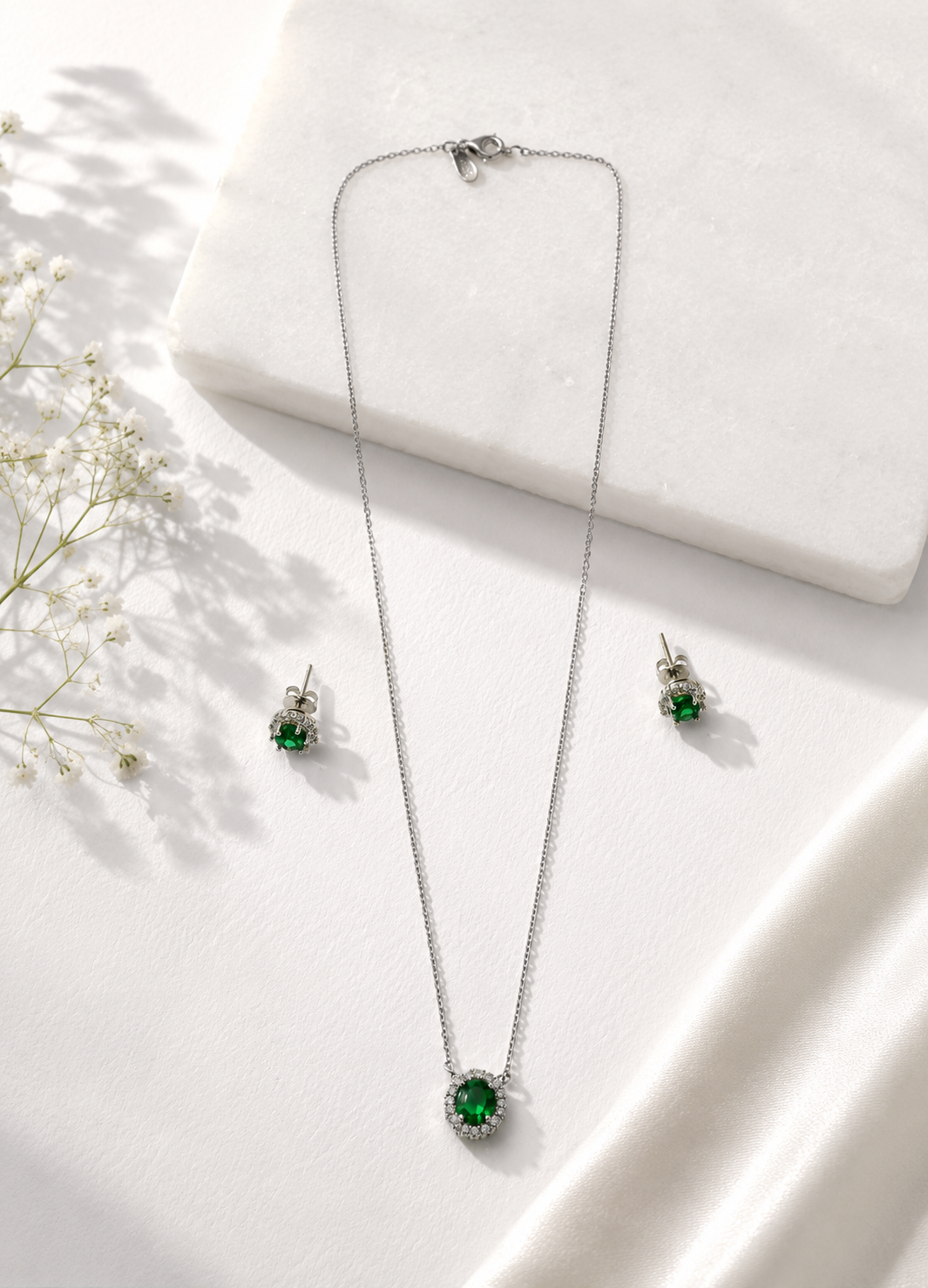 Elegant sterling silver jewelry set featuring emerald green cubic zirconia stones