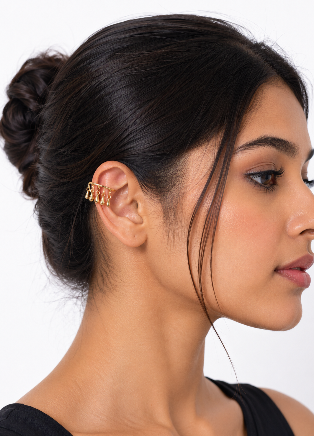 Woman wearing ORELVA gold tone adjustable ear cuff with dangling teardrop charms.