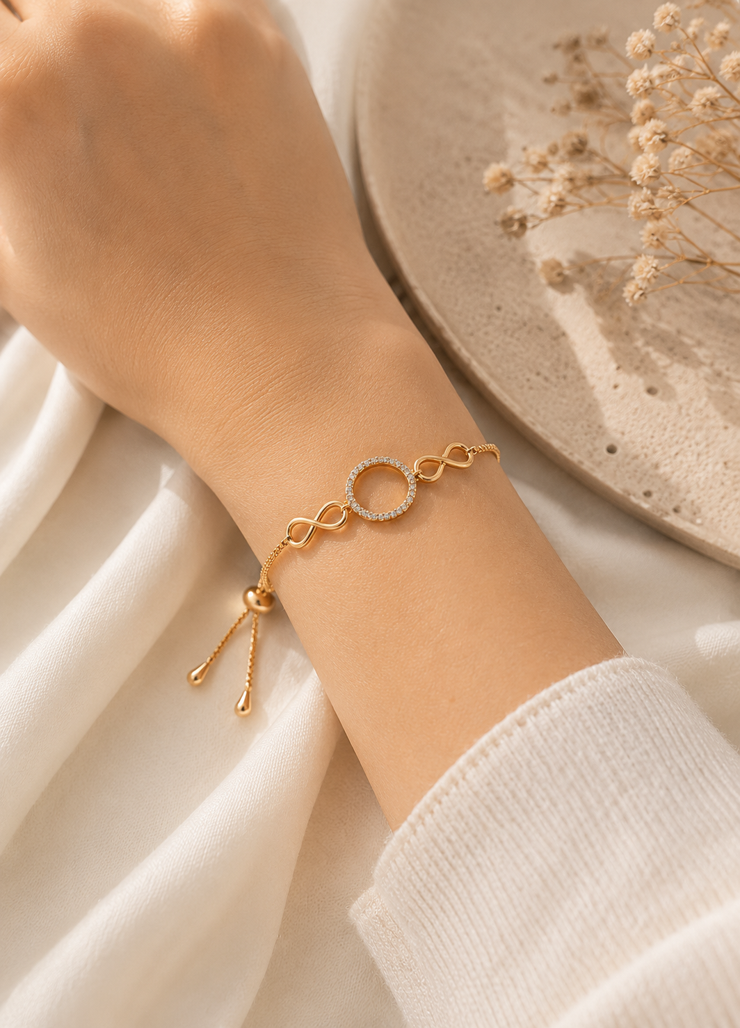 Woman wearing ORELVA Infinity Halo Adjustable Gold Bracelet with crystal circle charm.