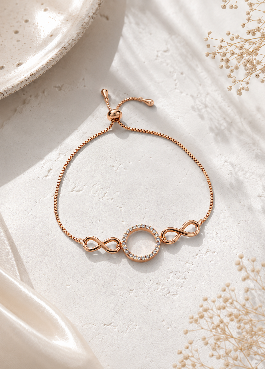 ORELVA Infinity Halo Rose Gold Adjustable Bracelet displayed on a premium marble background.