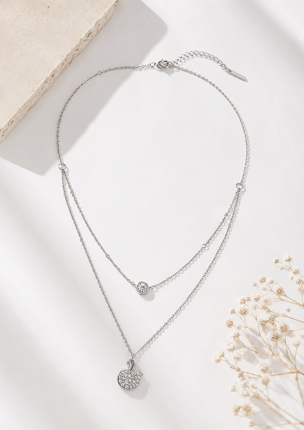 Minimal silver layered necklace featuring crystal pendants by ORELVA.