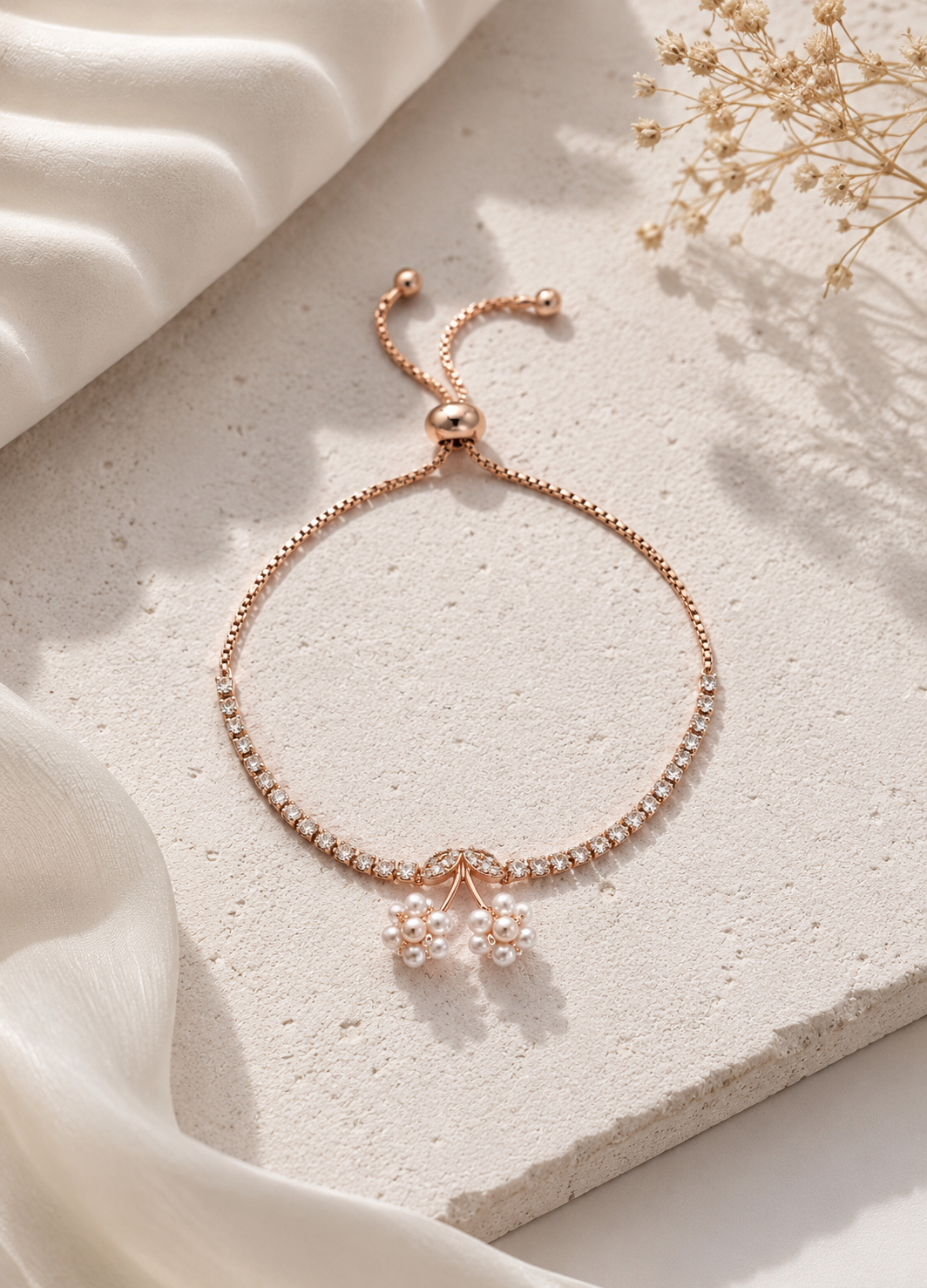 Rose gold crystal bracelet with pearl flower charms by Orelva on white background