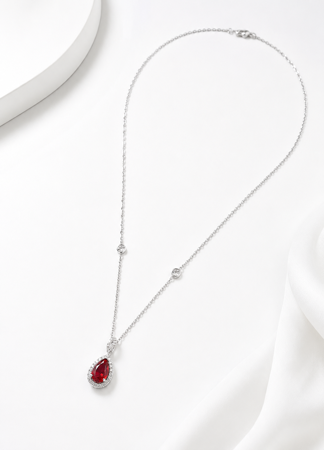 Elegant 925 sterling silver necklace with ruby red crystal pendant and brilliant halo detailing.