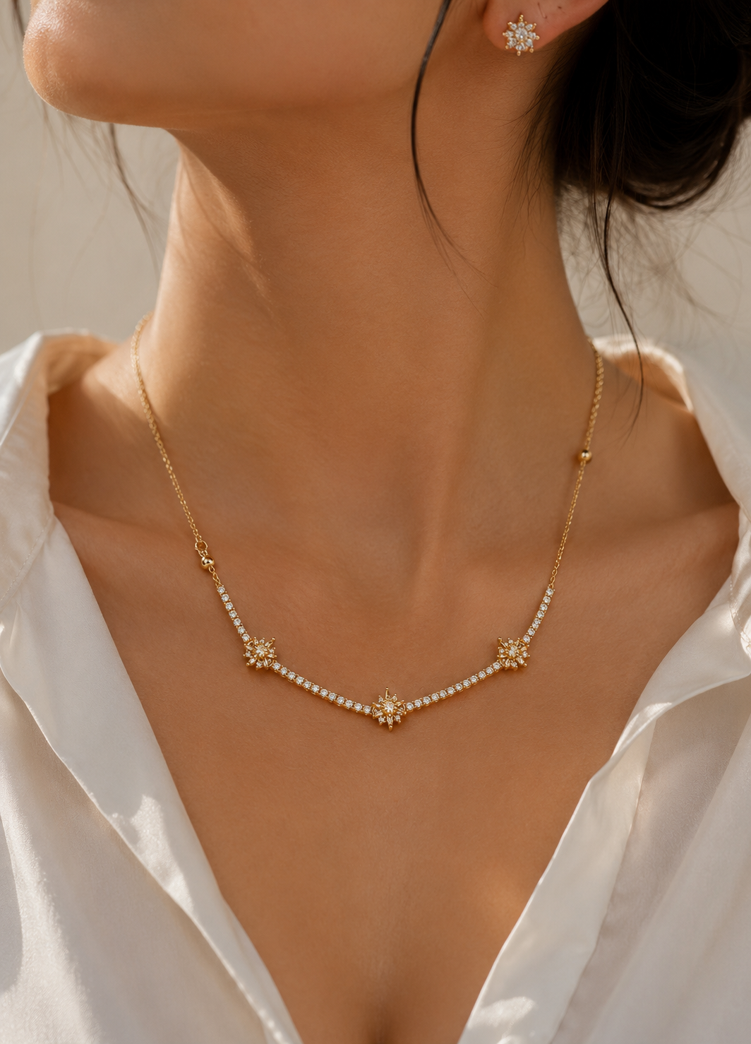 Gold-tone crystal necklace with matching star-inspired stud earrings for women.