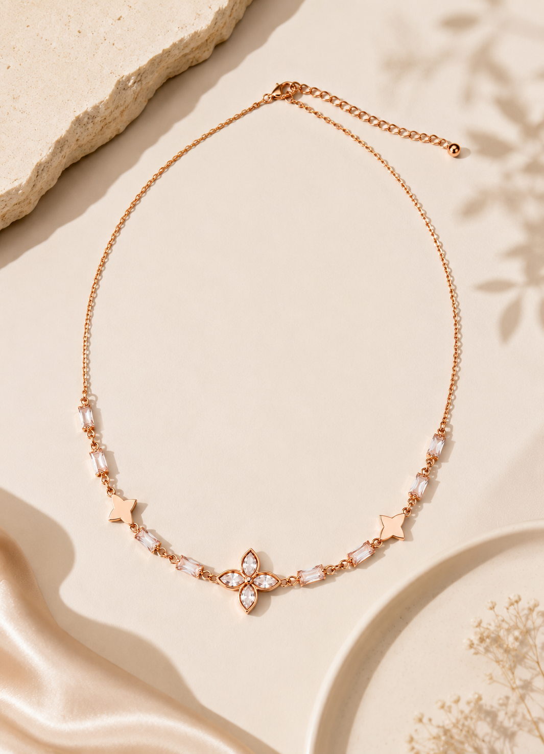 Elegant rose gold tone necklace with floral crystal pendant and baguette-cut crystal accents